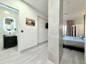 A modern bedroom with a bed, a bedside table, a nightstand, and a large window. - Studio with sea views Benalmádena (Benalmádena)