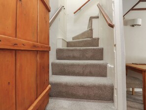Una escalera de madera con escalones alfombrados que conducen a un rellano.