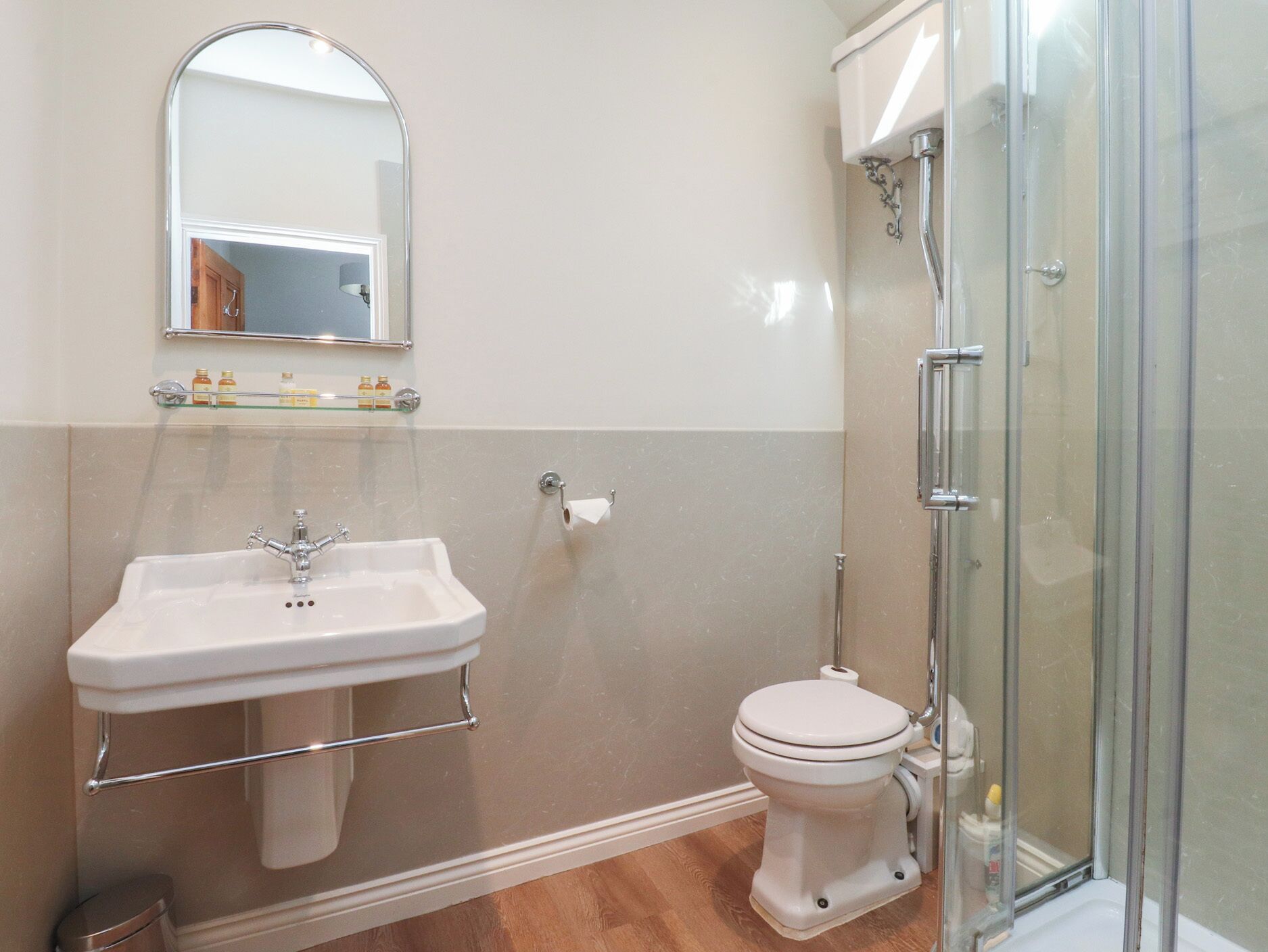 Une salle de bain équipée d’un lavabo, de toilettes et d’une douche à parois en verre.