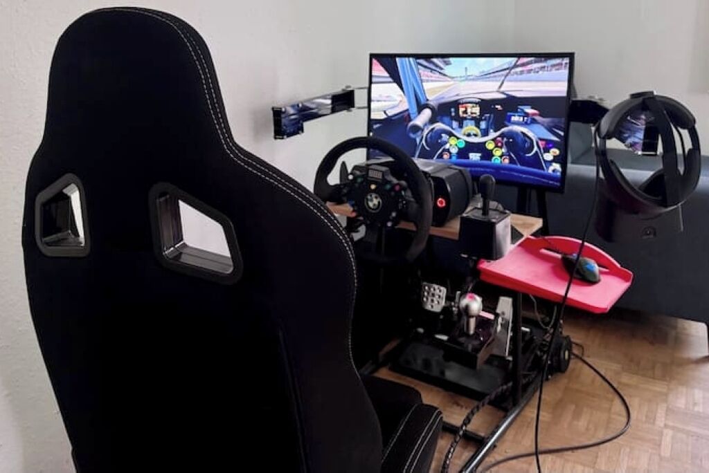 Een race simulator opstelling met stuurwiel, pedalen en een monitor waarop een racegame wordt weergegeven.
