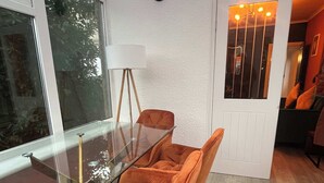 Uma área de refeições moderna com uma mesa de vidro e cadeiras estofadas em laranja.