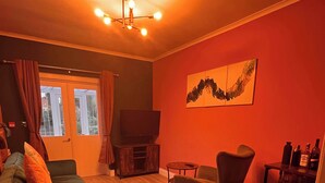 Uma sala de estar com sofá, poltronas, televisão e lareira.