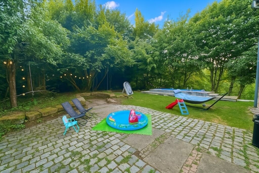 Ein Garten mit einem kleinen aufblasbaren Pool, einer Hängematte und einem Boot.
