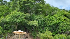 A dock with a wooden table and chairs, a bench, and a shaded area with an umbrella. - Ecoaraguaia Jungle Lodge (Caseara)