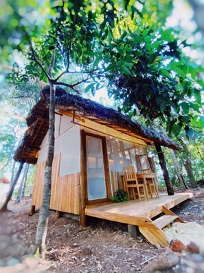 A wooden cabin with a thatched roof, large windows, and a wooden deck. - Ecoaraguaia Jungle Lodge (Caseara)