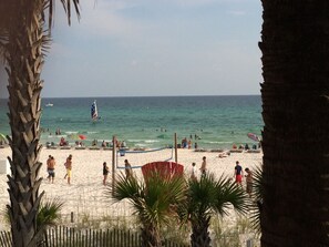 A beach with people, a volleyball net, and a sailboat in the distance. - Serene/Private 4-bedroom house nestled in West end of Panama City Beach (Panama City Beach)