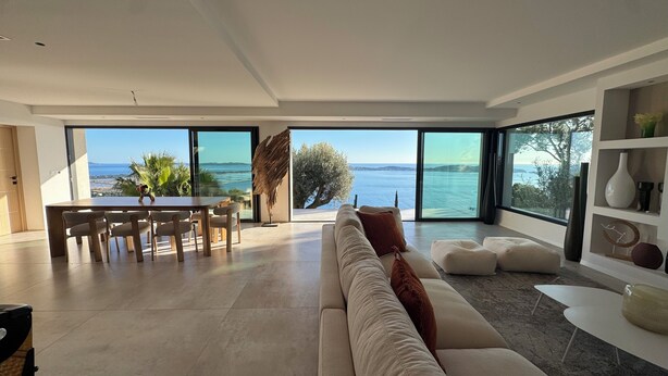 A modern living room with a large sliding glass door leading to a balcony with a sea view. - 180°C sea Giens peninsula (Carqueiranne)