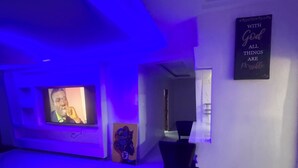 Une pièce avec une télévision, une citation inspirante sur le mur et un tapis sur le sol.