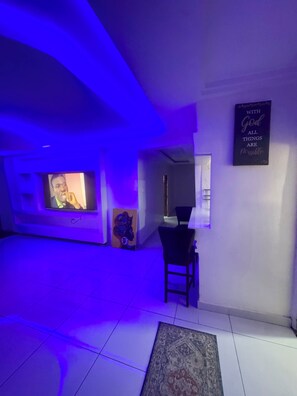 A room with a television, a motivational quote on the wall, and a rug on the floor.