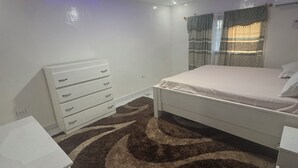 Une chambre à coucher avec un lit, une commode et une table de chevet.