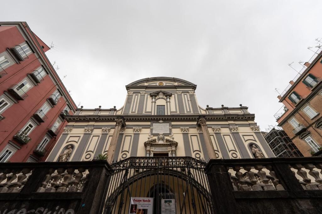 A classical building with a central dome and a gated entrance.
