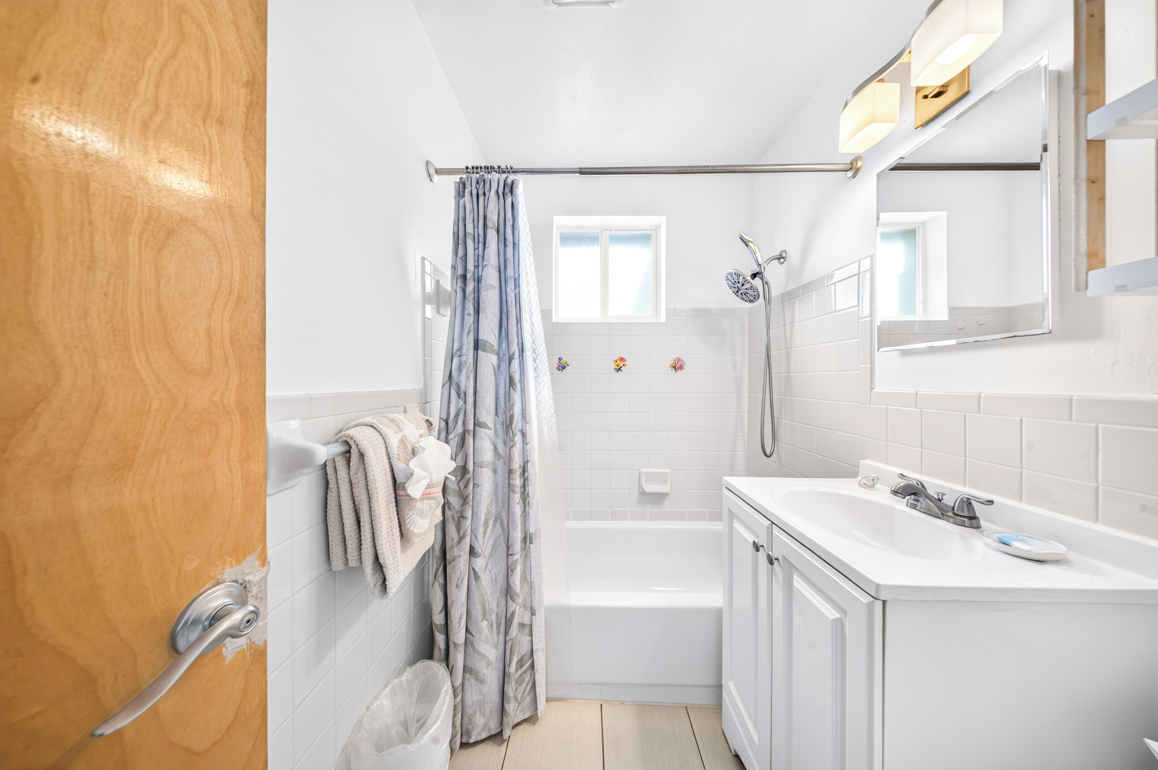 Un bagno con una vasca, una doccia, un lavandino e uno specchio.