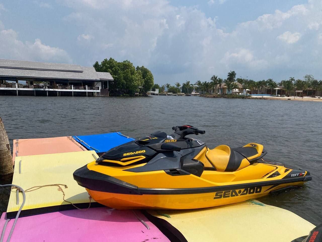 Ein gelbes Sea-Doo Wasserfahrzeug an einem Steg, im Hintergrund ein Gebäude.