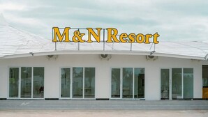 A modern building with the sign "M&N Resort" above the entrance.