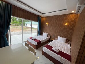 A hotel room with two beds, a dining table, and a view of the outside. - MN Koh Kong Resort (Khemarak Phoumin)