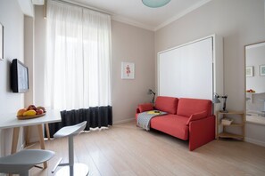 Suite Deluxe, balcón, vistas a la ciudad | Zona de estar | Televisión de pantalla plana de 40 pulgadas con canales por cable