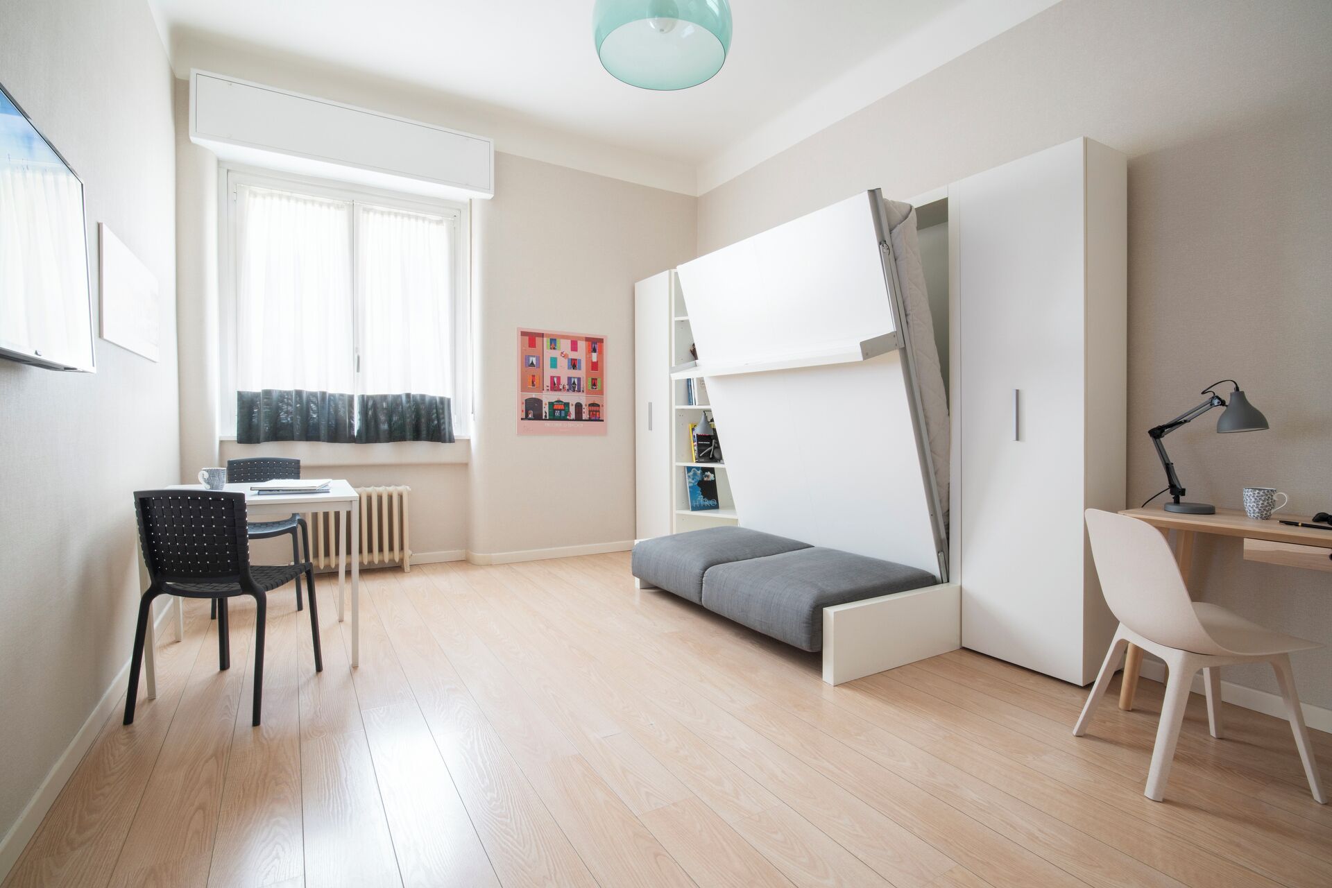 Un espace de vie moderne et compact comprenant un lit, un bureau et une chaise.