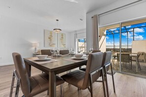 A modern dining area with a large table set for four, surrounded by leather chairs. - Stylish 6BR townhome w/ private pool•Near parks (Davenport)