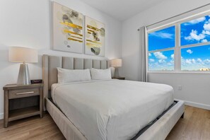 A bedroom with a bed, nightstands, lamps, and artwork on the wall. - Stylish 6BR townhome w/ private pool•Near parks (Davenport)