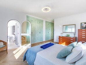 A bedroom with a bed, a dresser, a mirror, and a wardrobe. - Vacation home Monet by Interhome (Nerja)
