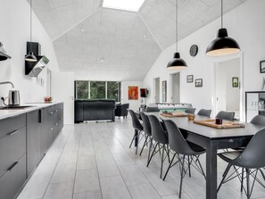 A modern kitchen with a dining area, featuring a foosball table, a large window, and a high ceiling. - "Eerika" - 500m to the fjord by Interhome (Vestervig)