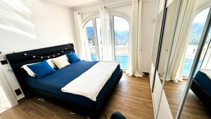 A bedroom with a large bed, a view of a pool, and a balcony. - Villa Serenity | Private pool, air conditioning, view of the bay of Roses, up to 13 people (El Mas Fumats)