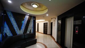 Un lobby de hotel moderno con un muro estampado con motivos de cebra, un diseño de techo circular y un ascensor.