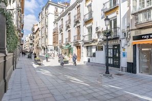 A pedestrian street lined with multi-story buildings, some with balconies and outdoor seating. - Room 'Habitación 207' with Wi-Fi and Air Conditioning (Granada)