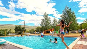 A swimming pool with people enjoying the water, surrounded by trees and a clear sky. - Camping Karin - Mobile houses Magoro (Donji Karin)
