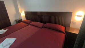 Ein Hotelzimmer mit einem großen Bett, zwei Nachttischen und Wandleuchten.