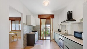 Une cuisine moderne dotée d’un îlot central, d’un four encastré et d’un four à micro-ondes.
