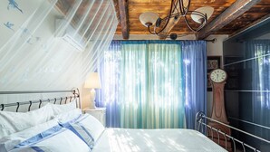 Une chambre à coucher avec un lit, des rideaux, une horloge et un plafond en bois.