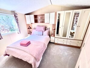 A bedroom with a bed, a wardrobe, and a window. - Cabin Sleeps 5, Patio, Pets, Pool, Peaceful Place (Dunbar)
