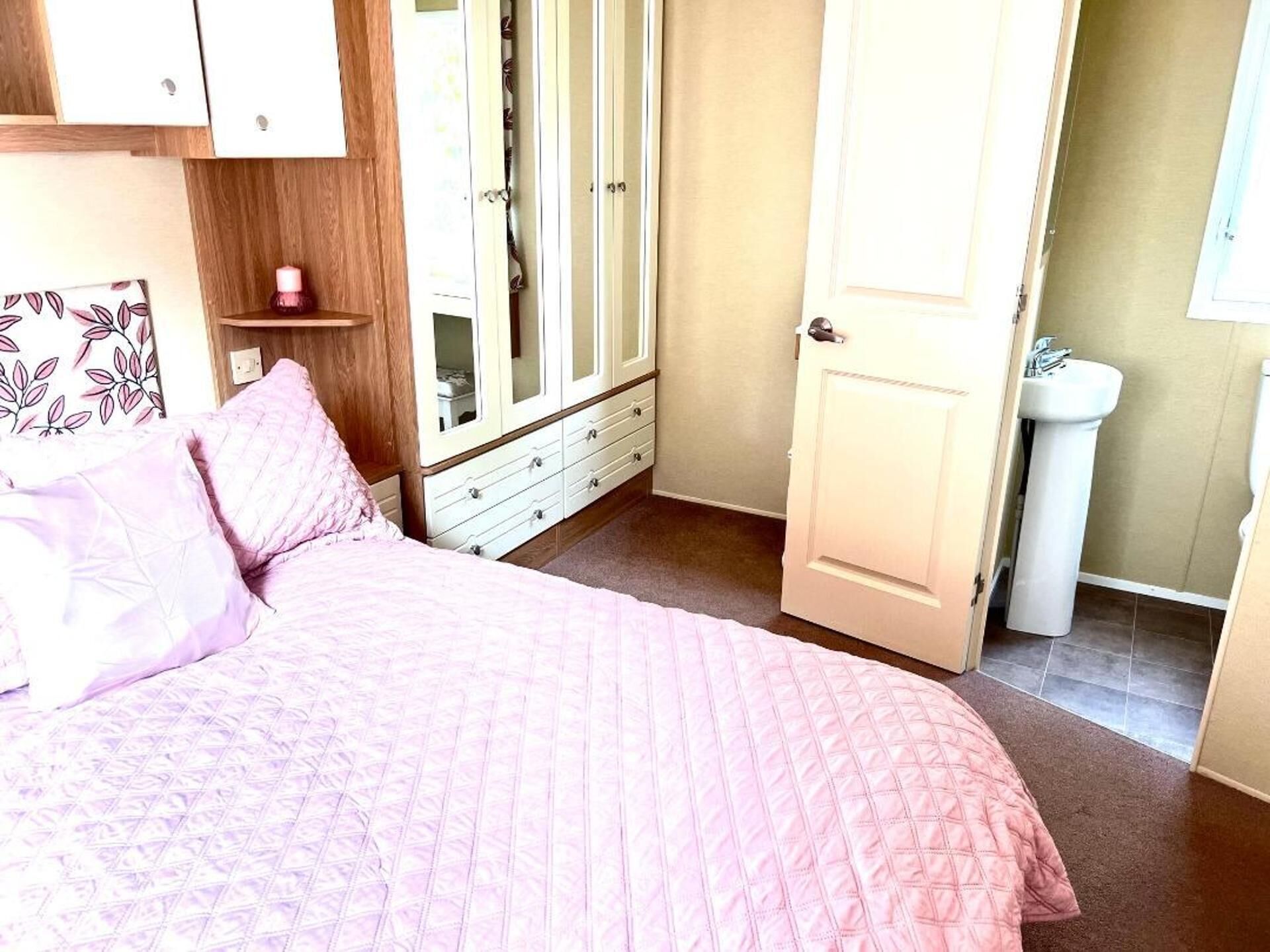 Een slaapkamer met een bed, een kledingkast en een badkamer.