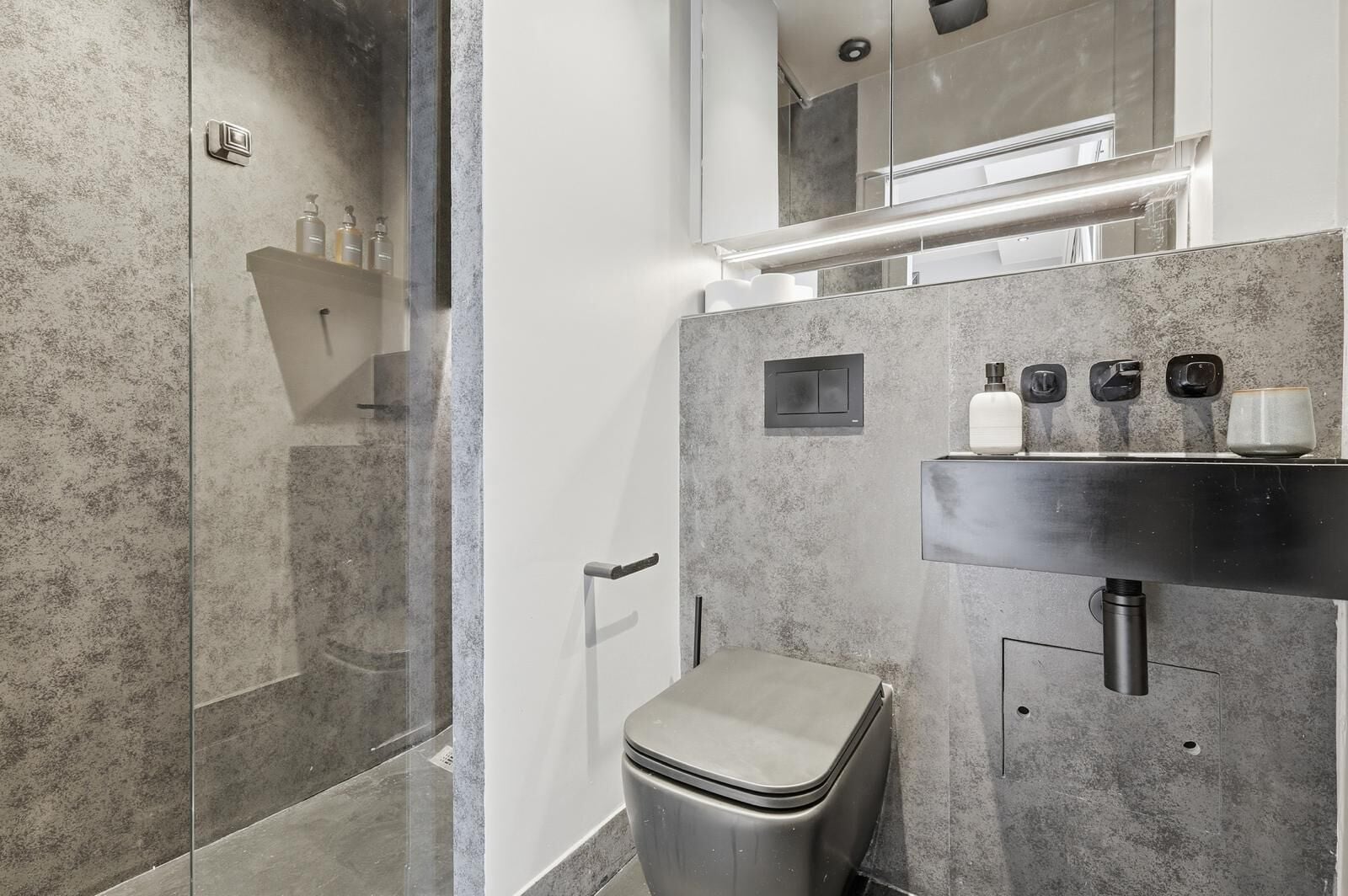 Luxe studio | Badkamer | Een douche, een haardroger, handdoeken, zeep