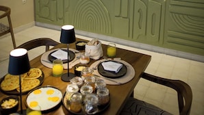 A dining area with a table set for breakfast, including plates, glasses, and a variety of food items. - Riad A l'Ombre du Palais (Marrakech)
