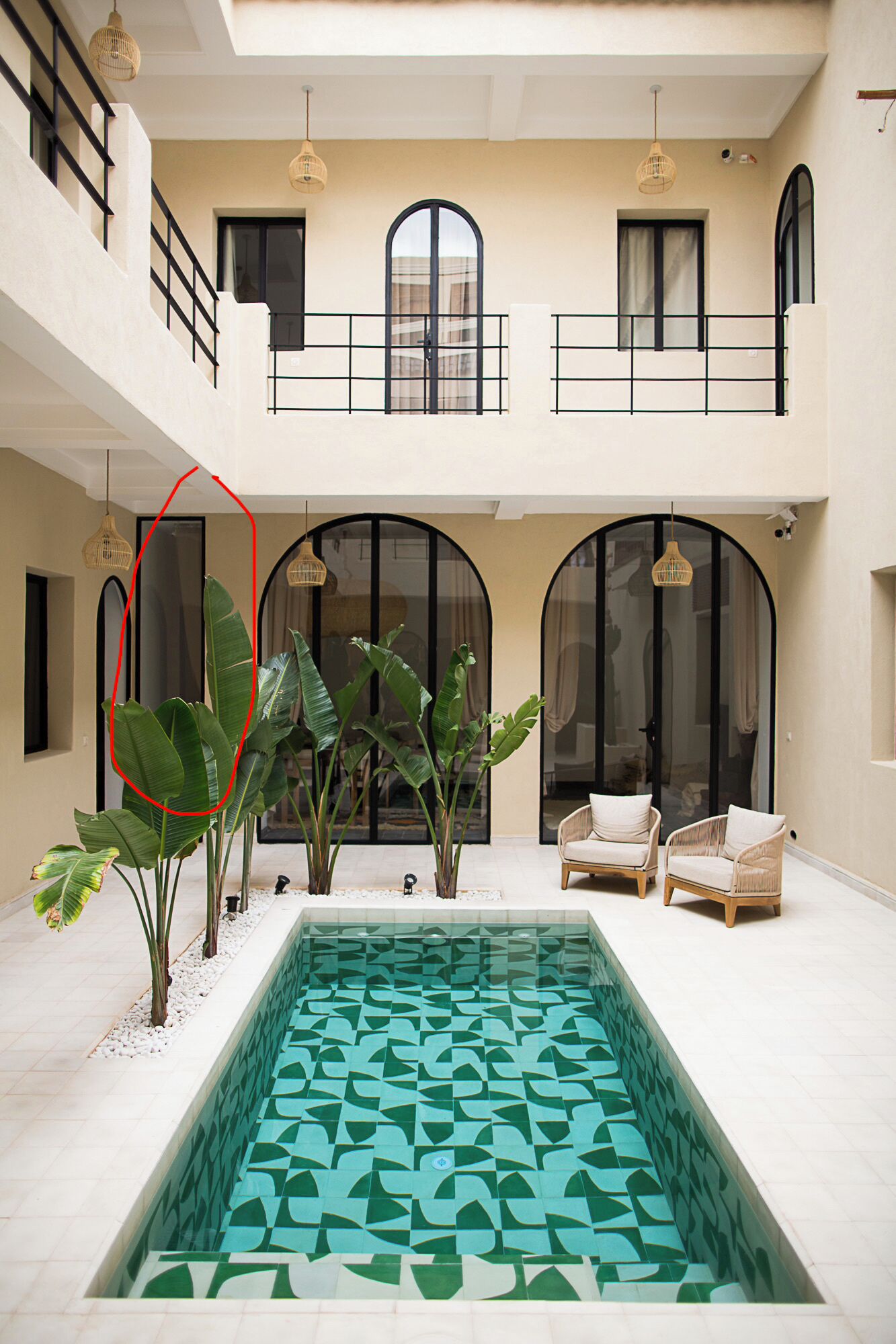 A spacious indoor area with a pool, seating, and large windows.