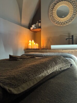 A bedroom with a bed, a mirror, and candles. - Riad A l'Ombre du Palais (Marrakech)