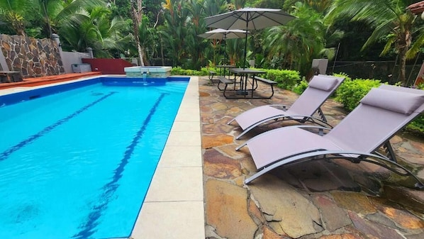 Una piscina al aire libre, sombrillas, tumbonas