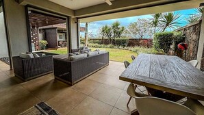 An open-plan living area with a dining table, two sofas, and a ceiling fan. - Luxurious & peaceful blend villa in Royal Park Balaclava Mauritius 3 (Balaclava)