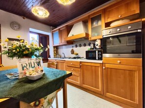 Una cocina con armarios de madera, microondas y estufa.