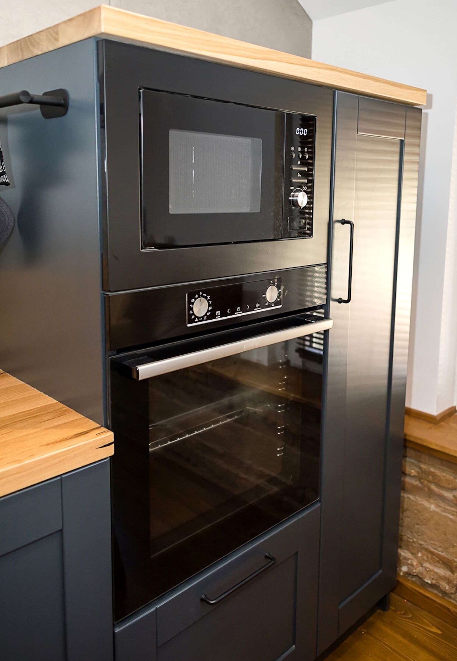 Une cuisine compacte équipée d’un four à micro-ondes, d’un four et d’un réfrigérateur intégrés.