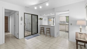 Eine moderne Küche mit weißen Schränken, einer Arbeitsplatte und einem Fenster.