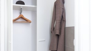 A walk-in closet with a hanging rod, shelves, and a radiator. - CIRENE APARTMENTS (Milan)