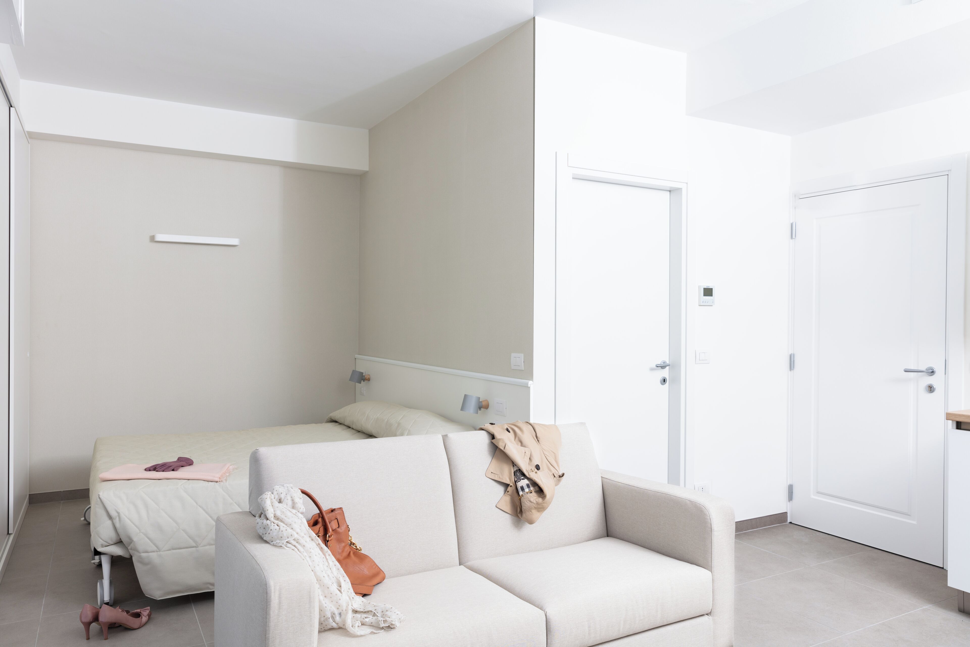 Una habitación de hotel moderna con una cama, un sofá y un escritorio.