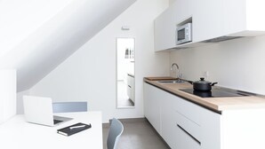 A modern kitchen with a laptop, a notebook, and a chair. - CIRENE APARTMENTS (Milan)