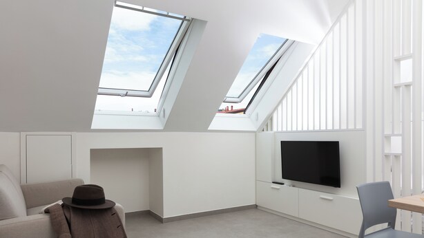 A modern, minimalist room with skylights, a flat-screen TV, a sofa, and a dining area. - CIRENE APARTMENTS (Milan)