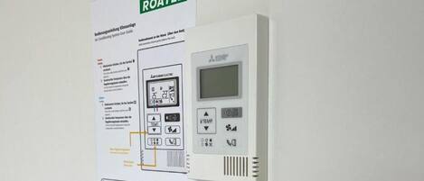 A ROATEL control panel with a digital display and several buttons for temperature and settings.