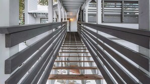 A wooden staircase with railings leading to a covered area. - Zephyr Chalet Steps from Zephyr Cove (Glenbrook)