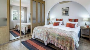 Habitación de hotel con una cama grande, un espejo, un armario y vistas al exterior.